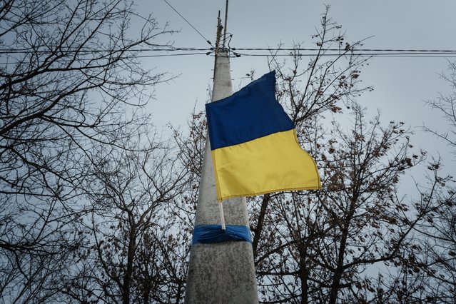 A Ukrainian national flag adorns an electrical post in Kupiansk, Kharkiv region, on February 13, 2023, amid the Russian invasion of Ukraine. (Photo by Yasuyoshi Chiba/AFP Photo)