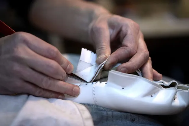 French shoemaker Guillaume Gonin works on a shoe for the famous Moulin Rouge cabaret on April 22, 2014 in Paris, in the workshop of the “Maison Clairvoy”. Since 1945, the “Maison Clairvoy” is specialised in the creation of luxury shoes and started in 1960 a collaboration with the famous Moulin Rouge to create boots and shoes for French Cancan dancers. (Photo by Franck Fife/AFP Photo)