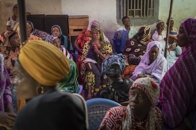 Mourners gather at the house of Ousmane Sylla's mother after his burial in Matoto Bonagui, a suburb of Conakry, Guinea, Tuesday, April 9, 2024. In Italy, he found despair. He spent months in a crowded, squalid migrant detention center, unable to contact his family. He died by suicide in February after other detainees said he became depressed and withdrawn. (Photo by Misper Apawu/AP Photo)
