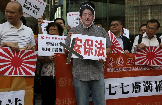 A protester wears a cutout of a defaced portrait of Japanese Prime Minister Shinzo Abe while holding a sign which reads “security bill”, as others carry illustrations of the Japanese military flag, during a demonstration outside the Japanese consulate in Hong Kong, China July 7, 2015. Tuesday marks the 78th anniversary of the start of the Sino-Japanese war. (Photo by Bobby Yip/Reuters)