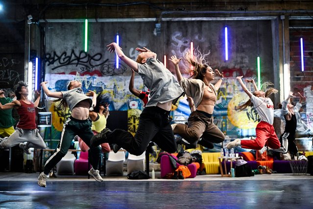 Dancers perform a choreography during a rehearsal for the opening ceremony of the Paris 2024 Olympic Games in Saint Denis, north of Paris, on June 7, 2024. Lyrical and epic music suddenly resonates in an abandoned hangar transformed into a ballroom. In front of a giant mirror, the dancers warm up before performing, for a few seconds, the first steps of a secret choreography. Audiences around the world will discover this choreography in its entirety on July 26, during the opening ceremony of the Olympic and Paralympic Games in Paris. (Photo by Julien de Rosa/AFP Photo)