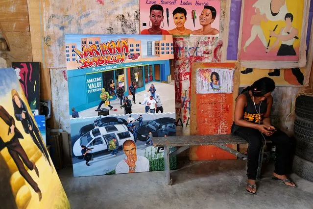 Apprentice Joana Tackie, 24 sits at the workshop of Ghanaian movie poster artist Daniel Anum Jasper in the area of Teshie, Ghana on February 11, 2022. (Photo by Francis Kokoroko/Reuters)
