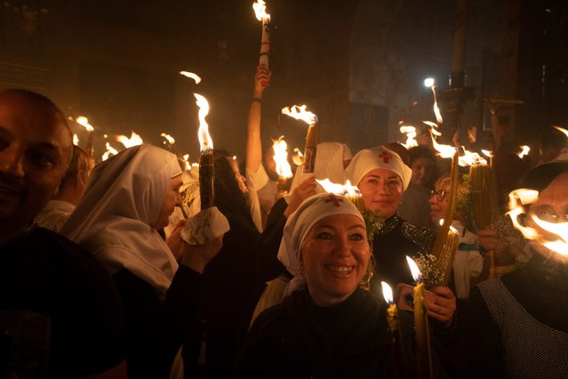 Christian Orthodox pilgrims hold candles during the Holy Fire ceremony at the Church of the Holy Sepulchre, where many Christians believe Jesus was crucified, buried and rose from the dead, in the Old City of Jerusalem, Saturday, May 4, 2024. In the annual ceremony that has been observed for over a millennium, a flame taken from Jesus' tomb is used to light the candles of fervent believers of Christian Orthodox communities near and far. The devout believe the origin of the flame is a miracle and is shrouded in mystery. (Photo by Leo Correa/AP Photo)