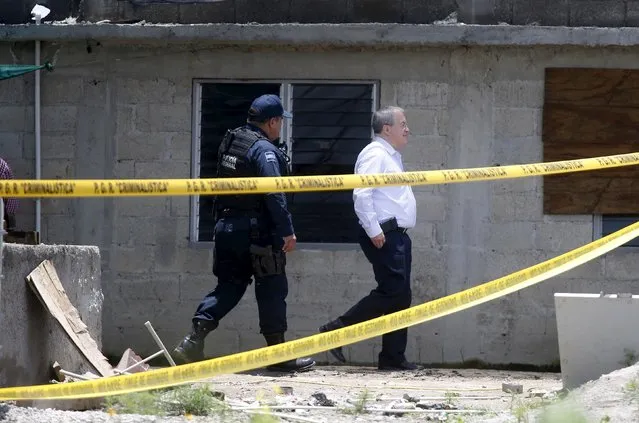 National Security Commissioner Monte Alejandro Rubido (R) inspects a warehouse where a tunnel connected to the Altiplano Federal Penitentiary and used by drug lord Joaquin “El Chapo” Guzman to escape was located in Almoloya de Juarez, on the outskirts of Mexico City, July 15, 2015. (Photo by Edgard Garrido/Reuters)