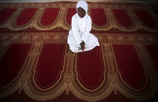 A girl looks on during Eid al-Fitr, marking the end of the holy month of Ramadan, at a mosque in Adjame, in the Ivorian capital Abidjan, July 17, 2015. (Photo by Thierry Gouegnon/Reuters)