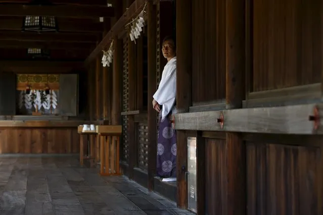A Shinto priest waits for Japanese lawmakers to return from the main building of the Yasukuni shrine where they pay respects to the country's war dead in Tokyo, Japan April 22, 2016. (Photo by Thomas Peter/Reuters)