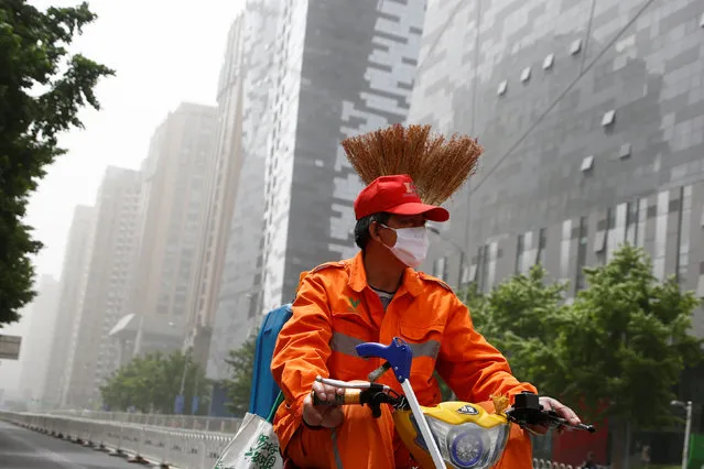 A street cleaner wears a face mask as a dust storm hits Beijing, China May 4, 2017. (Photo by Thomas Peter/Reuters)