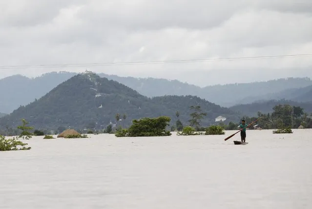 A man rows his boat along a flooded rice field in Kawlin township, Sagaing division, Myanmar, July 21, 2015. (Photo by Soe Zeya Tun/Reuters)