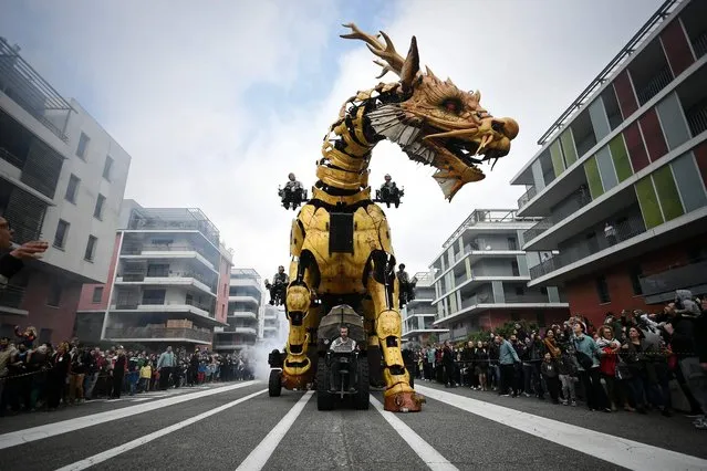 Operators drive the dragon-horse called Long-Ma, created by Francois de la Roziere and his company “La Machine”, in the streets of Toulouse, southern France, on April 16, 2022. Long-Ma goes to meet the Minotaur, at the “Halle des Machines”. This scene is the first of the weekend, during which Long Ma comes alive and walks on the “Piste des Géants” in Toulouse. (Photo by Valentine Chapuis/AFP Photo)