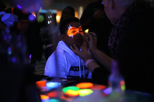 A boy has his face painted with fluorescent paint during the Vivid Sydney festival of light and sound in Sydney, Australia, May 26, 2017. (Photo by Steven Saphore/Reuters)