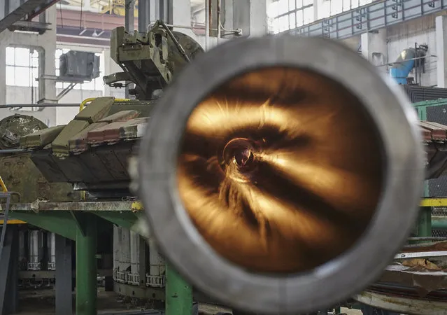 A Ukrainian worker looks through the barrel from inside a tank turret at the Kharkiv's Armored Plant where Ukrainian T-80 tanks are modified, in Kharkiv, Ukraine, 13 July 2015 before they reportedly will be send to the conflict zone at the eastern Ukraine. While the military equipment was prepared, the special representative of the Organization for Security and Cooperation in Europe (OCSE) on 07 July expressed hopes that a new accord on withdrawing weapons from Ukraine's conflict zone can be agreed soon. (Photo by Sergei Kozlov/EPA)