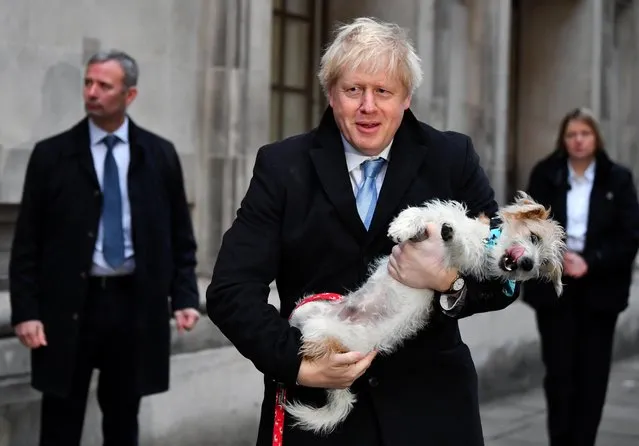 Britain's Prime Minister Boris Johnson holds his dog Dilyn as he leaves a polling station, at the Methodist Central Hall, after voting in the general election in London, Britain, December 12, 2019. (Photo by Dylan Martinez/Reuters)