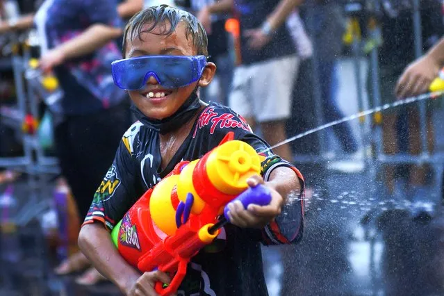 A boy plays with water as he celebrates during the Songkran holiday which marks the Thai New Year during the coronavirus disease (COVID-19) outbreak, in Bangkok, Thailand, April 13, 2022. (Photo by Chalinee Thirasupa/Reuters)