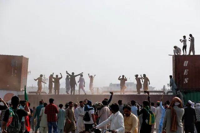 Supporters of the Pakistan Tehreek-e-Insaf (PTI) political party react after they remove a shipping container, used to block the road leading to Red Zone, during a protest march called by ousted Prime Minister Imran Khan in Islamabad, Pakistan on May 26, 2022. (Photo by Akhtar Soomro/Reuters)