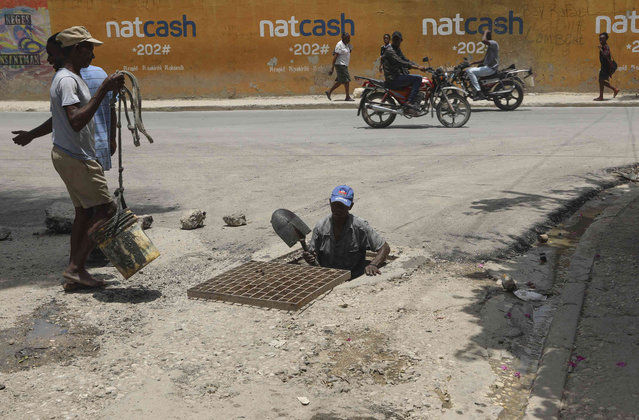 Workers remove garbage from a sewer in Port-au-Prince, Haiti, Monday, July 15, 2024. (Photo by Odelyn Joseph/AP Photo)