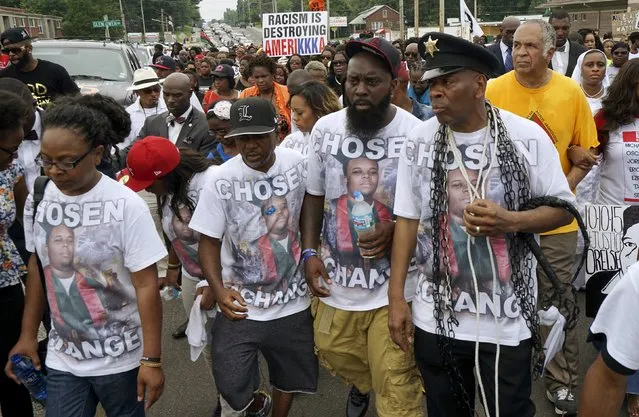 Michael Brown Sr. (2nd R) leads a march after an event to mark the one-year anniversary of the killing of his son Michael Brown in Ferguson, Missouri August 9, 2015. Hundreds of people marched, prayed and held moments of silence in Ferguson, Missouri on Sunday to mark the anniversary of the shooting death of an unarmed black teenager by a white police officer a year ago. (Photo by Rick Wilking/Reuters)