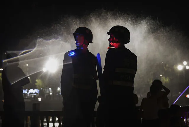 Police officers guard near a new laser and water show that is part of a local government tourism development on June 30, 2017 in the old town of Kashgar, in the far western Xinjiang province, China. (Photo by Kevin Frayer/Getty Images)