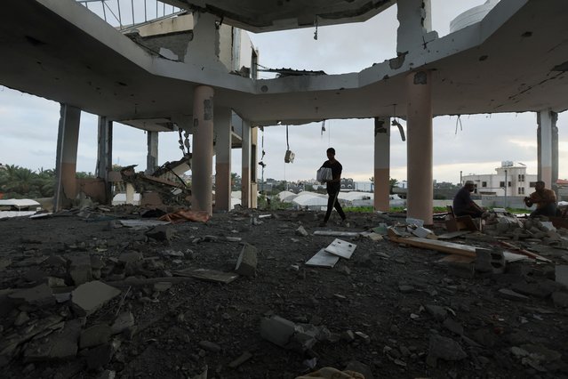 A Palestinian walks with copies of Koran at the site of an Israeli strike on a mosque sheltering displaced people, amid Israel-Hamas conflict, in Deir Al-Balah, in the central Gaza Strip, on October 6, 2024. (Photo by Ramadan Abed/Reuters)