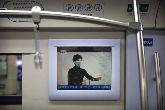 A public service announcement that encouraging people to wear face masks plays on a subway train during the morning rush hour in Beijing, Monday, February 3, 2020. Much of China officially went back to work on Monday after the Lunar New Year holiday was extended several days by the government due to a virus outbreak, but China's capital remained largely empty as local officials strongly encouraged non-essential businesses to remain closed or work from home. (Photo by Mark Schiefelbein/AP Photo)