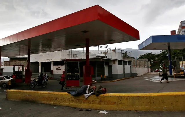 A man rests next to a gas station in Caracas, Venezuela, June 21, 2016. (Photo by Mariana Bazo/Reuters)