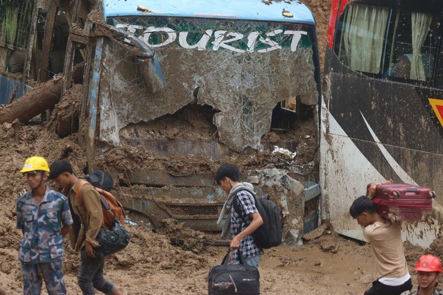 Nepali passengers stranded along the Prithvi Highway of Nepal walk on foot towards their destination as landslides obstruct the highway for the past three days in Dhading District on September 29, 2024. (Photo by Aryan Dhimal/ZUMA Press Wire/Rex Features/Shutterstock)