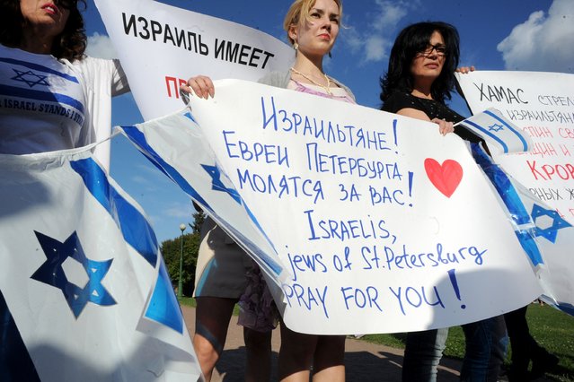 A picture taken  in the Russia's second city of St. Petersburg on July 21, 2014, shows pro-Israeli activists rallying in support of the Israeli campaign of shelling and airstrikes in the Gaza Strip. Israel says its campaign aims to stamp out rocket fire from Gaza, and the ground phase of the operation to destroy tunnels burrowed into Israel by Hamas, the main power in the coastal strip. (Photo by Olga Maltseva/AFP Photo)