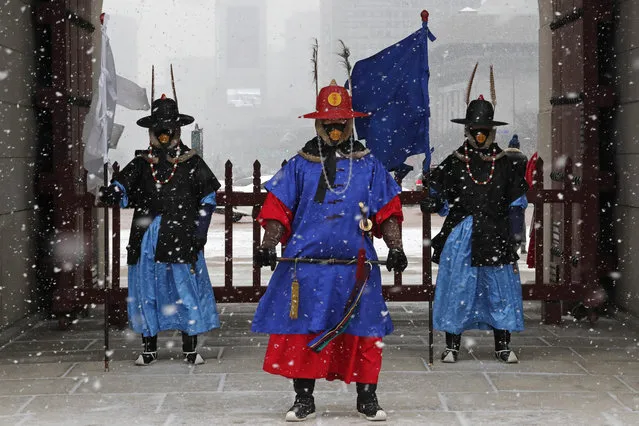 Imperial guards wearing face masks stand in the snow at the Gyeongbok Palace, the main royal palace during the Joseon Dynasty, in Seoul, South Korea, Monday, February 17, 2020. Chinese authorities on Monday reported a slight upturn in new virus cases and hundred more deaths for a total of thousands since the outbreak began two months ago. (Photo by Ahn Young-joon/AP Photo)