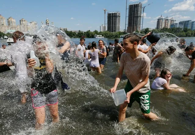 Youngsters play with water during a flash mob called “Water battle” on a hot summer day on the bank of the Dnipro river in Kiev, Ukraine, July 2, 2016. (Photo by Valentyn Ogirenko/Reuters)