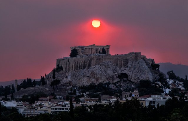 Smoke rises over the Acropolis Hill and the Parthenon from a wildfire that is burning at the western suburbs of the city of Athens, on August 22, 2023 (Photo by Andrea Bonetti/SOOC via AFP Photo)