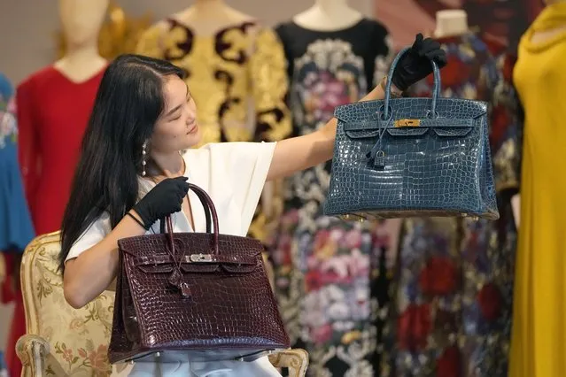 A model holds Hermes bags during a Haute Couture pre auction photo call at Bonhams auction house in London, Thursday, July 21, 2022. The Colvert Porosus Crocodile Birkin bags are estimated at 24,000 -26,000 pound sterlings, 28,000-31,000 dollars. (Photo by Frank Augstein/AP Photo)