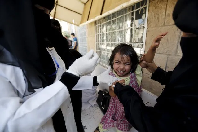 A girl cries as she receives polio vaccine drops at a school in Sanaa sheltering people after conflict forced them to flee their homes in Yemen's Houthi-controlled northern province of Saada August 15, 2015. (Photo by Khaled Abdullah/Reuters)