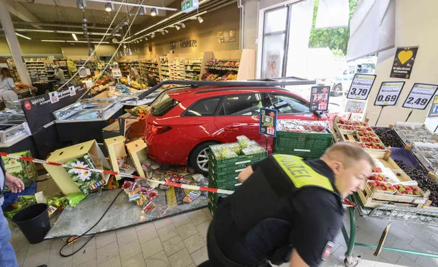 A car stand in a super market after an accident in Brunswick, Germany, Tuesday, July 26, 2022. In the morning, a 74-year-old man lost control of his vehicle while backing out of the parking space and reversed into the supermarket. Several people were injured. (Photo by Julian Stratenschulte/dpa via AP Photo)
