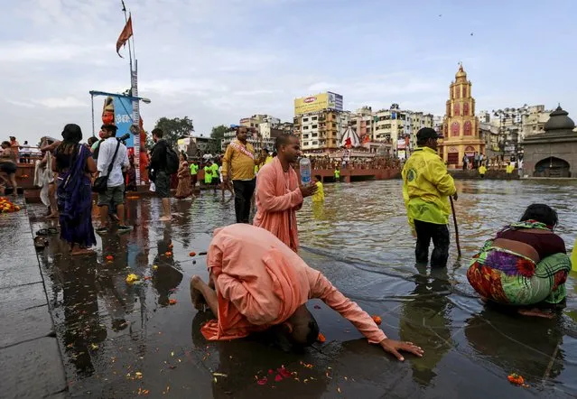 Sadhus or Hindu holy men pray along the Godavari river during the first Shahi Snan (grand bath) at Kumbh Mela, or Pitcher Festival in Nashik, India, August 29, 2015. (Photo by Danish Siddiqui/Reuters)