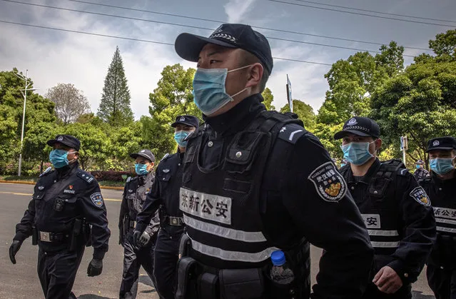 Police officers wearing protective face masks after the departure ceremony for Chinese medical workers from Shandong province, in Wuhan, China, 06 April 2020. Wuhan, the epicenter of the coronavirus outbreak, will lift the lockdown on 08 April allowing people to leave the city after more than two months. According to Chinese government figures over 2,500 people have died of Covid-19 in Wuhan since the outbreak began. (Photo by Roman Pilipey/EPA/EFE)