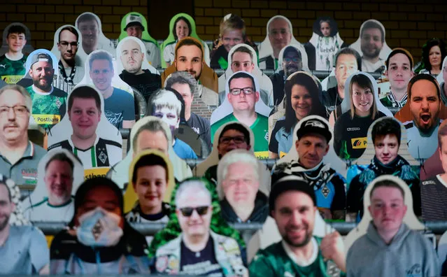 Cardboard cut-outs with portraits of Borussia Moenchegladbach's supporters are seen at the Borussia Park football stadium in Moenchengladbach, western Germany, on April 16, 2020, amid the novel coronavirus COVID-19 pandemic. Large-scale public events such as football matches will remain banned in Germany until August 31 due to the coronavirus crisis, Berlin said on Wednesday, April 15, 2020, though it did not rule out allowing Bundesliga games to continue behind closed doors. (Photo by Ina Fassbender/AFP Photo)