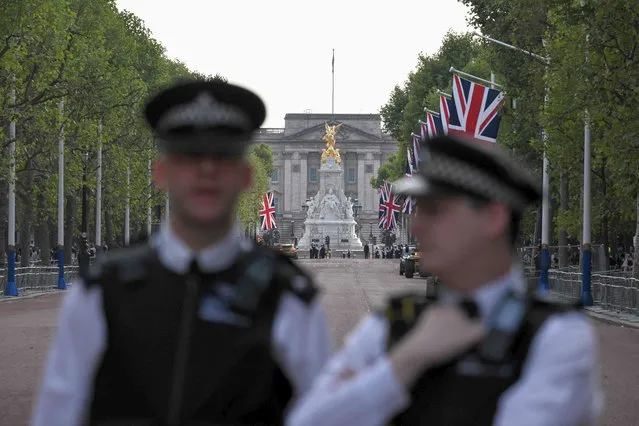 Police officers stand guard outside of Buckingham Palace in London on September 10, 2022, two days after Queen Elizabeth II died at the age of 9. (Photo by Loic Venance/AFP Photo)