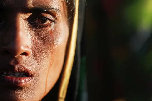 Amina Khatun, a 30 year old Rohingya refugee who fled with her family from Myanmar a day before, cries after she, along with thousands of newly arrived refugees, spent a night by the road between refugee camps near Cox's Bazar, Bangladesh October 10, 2017. Amina said her village in Buthidaung region was attacked by Myanmar military and burnt down, and that she didn't eat anything for the past three days. (Photo by Damir Sagolj/Reuters)
