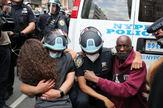 Police officers embrace with demonstrators during a protest against the death in Minneapolis police custody of George Floyd, in the Manhattan borough of New York City, U.S., June 2, 2020. (Photo by Jeenah Moon/Reuters)