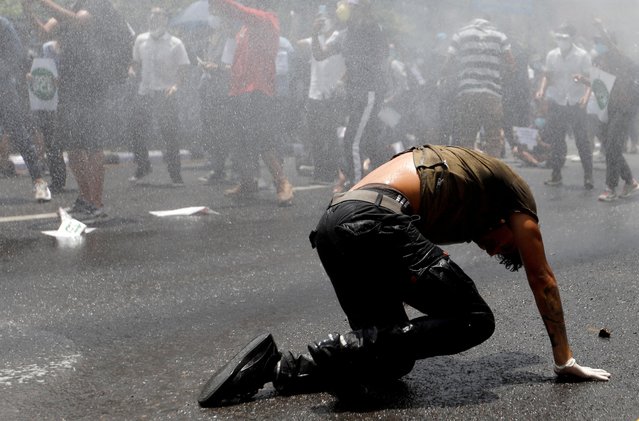 A protester crawls after being hit by a water cannon during a protest near the Prime Minister's official residence, demanding better and effective response from the government to fight the coronavirus disease (COVID-19) outbreak as the number of infections spike, in Kathmandu, Nepal on June 9, 2020. (Photo by Navesh Chitrakar/Reuters)