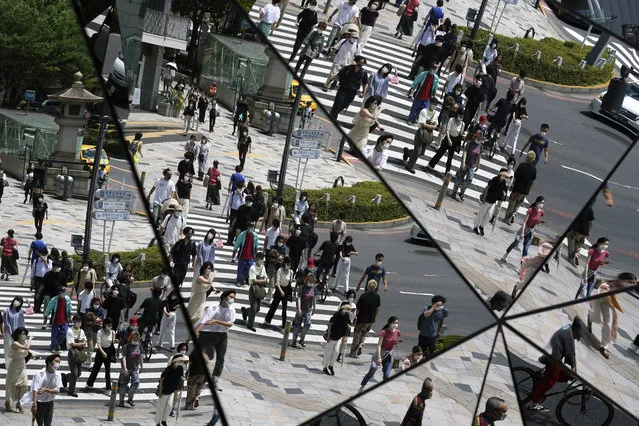 Pedestrians are reflected on a mirror ceiling of a shopping mall Thursday, June 11, 2020, in Tokyo. Hot weather continues in the metropolitan area as the temperature is expected to rise to 31 degrees Celsius (87.8 degrees Fahrenheit), according to Japan's meteorological bureau. (Photo by Eugene Hoshiko/AP Photo)