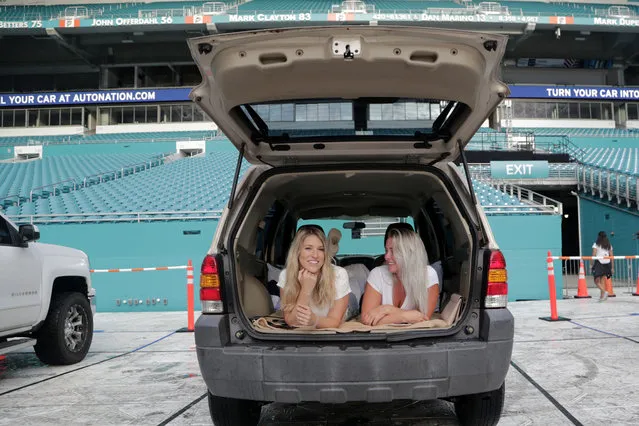 Amanda Scherner, left, and Rachel Anhalt sit in their vehicle to watch a movie as part of the Outdoor Theater program offered by the Miami Dolphins at the Hard Rock Stadium amid the new coronavirus pandemic, Thursday, June 18, 2020, in Miami Gardens, Fla. The outdoor theater program offers a safe way for residents to safely get out of their homes and remain socially distant. (Photo by Lynne Sladky/AP Photo)
