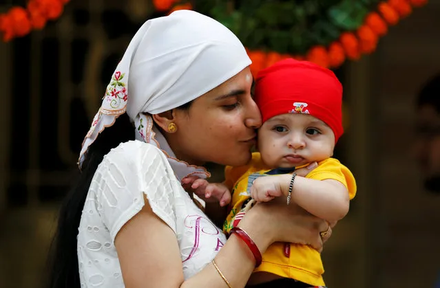 A woman kisses her son at a fire temple during the Parsi New Year celebrations in Ahmedabad, India, August 17, 2016. (Photo by Amit Dave/Reuters)