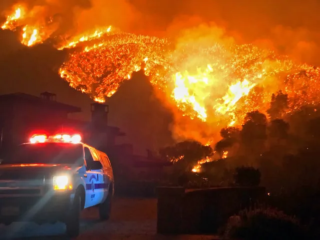 In this photo provided by the Santa Barbara County Fire Department, fire burns canyons and ridges above Bella Vista Drive near Romero Canyon as the fight to contain a wildfire continues in Montecito, Calif., Tuesday, December 12, 2017. The fifth-largest wildfire in California history expanded Tuesday, ripping through dry brush atop a coastal ridge while crews struggled to keep flames from roaring down into neighborhoods amid fears of renewed winds. (Photo by Mike Eliason/Santa Barbara County Fire Department via AP Photo)