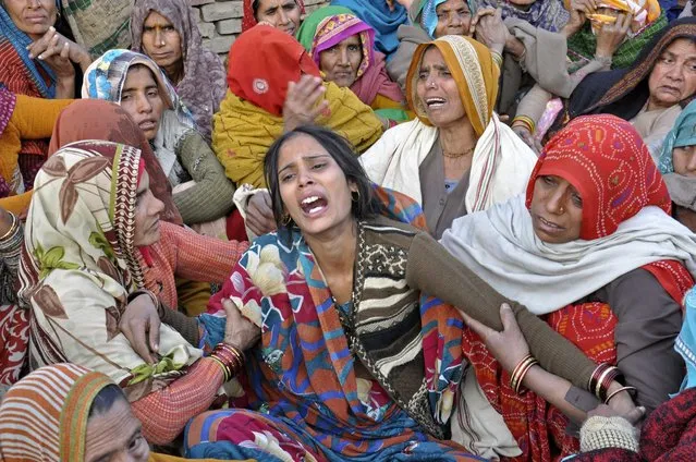 Dharamvati (C), wife of Indian soldier Hemraj Singh, weeps outside her house before Singh's body was brought for cremation in the Mathura district of the northern Indian state of Uttar Pradesh January 9, 2013. India denounced Pakistan on Wednesday over a firefight in the disputed territory of Kashmir in which two Indian soldiers were killed, but the nuclear-armed rivals both appeared determined to prevent the clash escalating into a full diplomatic crisis. (Photo by Reuters/Stringer)