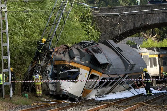 Spanish emergency services members and Civil Guard officers work at the site where a train derailed near O Porrino in Pontevedra, resulting in the death of at least two people and several others injured, in the northwestern province of Galicia, Spain, 09 September 2016. The train covering the Vigo-Oporto (Portugal) route was carrying some 60 passengers when one of its three coaches overturned provoking the accident. Spanish rail service Renfe has confirmed that at least two people were dead and a large number injured, some of them serious. Renfe also said that the train belongs to Portuguese company Comboios and that the engine driver has Portuguese citizenship. (Photo by Salvador Sas/EPA)