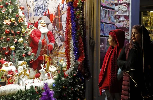 Iranians walk past a shop selling Christmas decoration in the capital Tehran on December 25, 2022. (Photo by AFP Photo/Stringer)