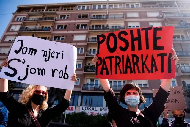 Women hold placards reading “I am a human not a slave” (L) and “Down Patriarchy” during a protest against gender violence and patriarchy in Pristina on September 23, 2020. (Photo by Armend Nimani/AFP Photo)