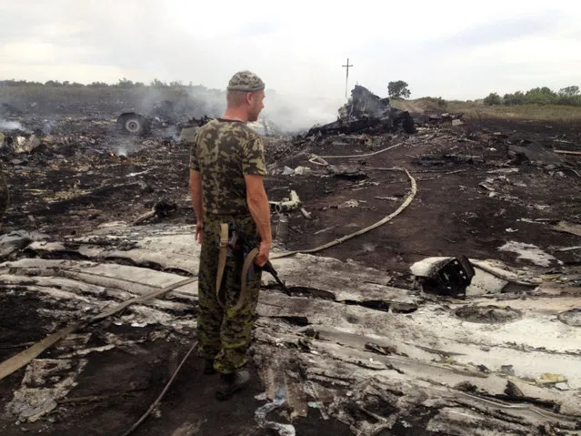 An armed pro-Russian separatist stands at a site of a Malaysia Airlines Boeing 777 plane crash in the settlement of Grabovo in the Donetsk region, July 17, 2014. (Photo by Maxim Zmeyev/Reuters)