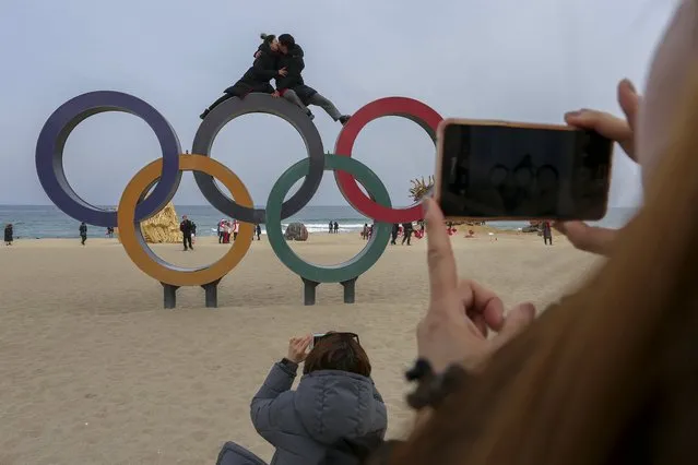 Tourists posing for photos sit on top of the Olympic rings at Gyeongpo beach near the Olympic village in Gangneung, South Korea, 19 February 2018. (Photo by Valdrin Xhemaj/EPA/EFE)