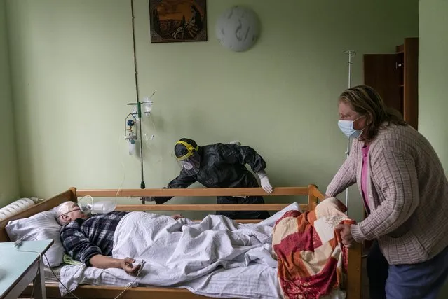A nurse, center, moves a bed with a coronavirus patient in a hospital intensive care unit in Stryi, western Ukraine, on Tuesday, September 29, 2020. (Photo by Evgeniy Maloletka/AP Photo)